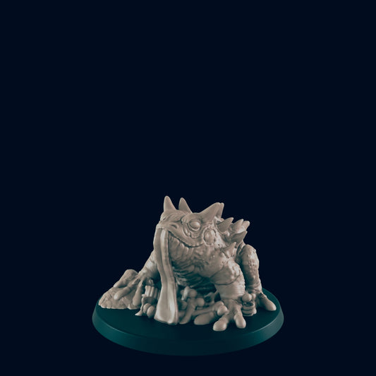 A toad miniature, sculpted with its tongue extended, rests on a dark circular base against a black background.