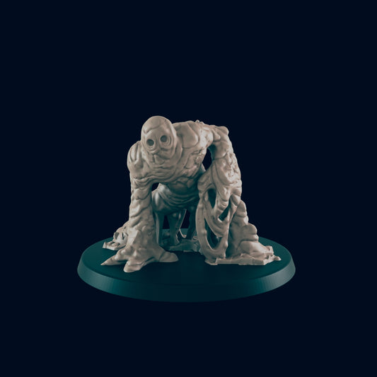 A clay-like humanoid figure with a featureless face stands, arms outstretched, on a dark green circular base against a dark blue background.