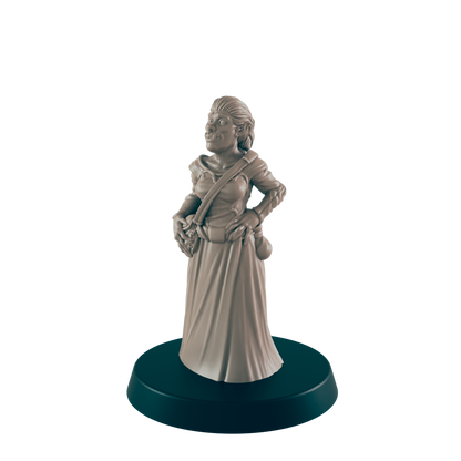 A female orc miniature stands on a circular base; she wears a long dress and satchel, hands on hips.