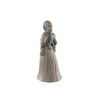 A miniature female figure, standing with her back to the viewer, is presented against a dark background.  She wears a long dress and has her hair in a braid.