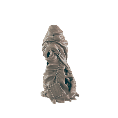A sculpted figure, appearing humanoid and cloaked, sits against a dark background.  The cloak is tattered and stitched, showing glimpses of the figure underneath.