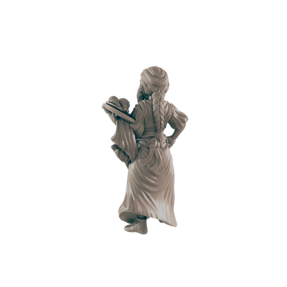 A miniature figurine of a woman carries a tray of food, viewed from behind against a dark background.