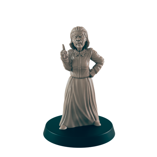 A miniature figurine of an angry woman, stands with one hand on her hip and the other raised in reprimand, on a circular base.