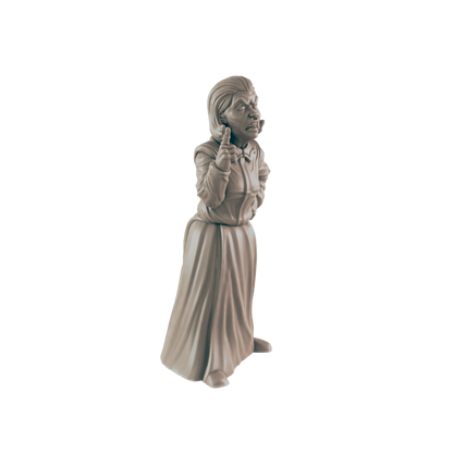A sculpted figurine of an elderly woman, standing with a finger pointed, is presented against a black background.