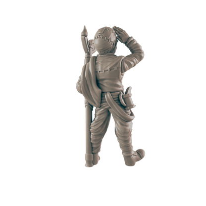 A miniature figurine of a person, possibly a soldier, stands holding a long staff, shielding their eyes against the sun.  The context is unknown, but the figurine is seemingly isolated.