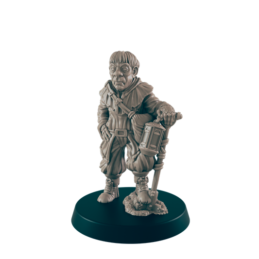 A miniature figurine of a stout, hooded figure stands holding a lantern-topped staff.  The figure is posed on a dark circular base.