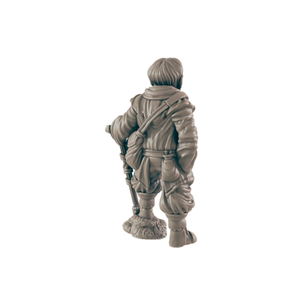 A miniature figurine of a traveler, standing with a staff, wears a hooded cloak and satchel against a dark background.