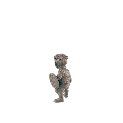 A small, sculpted figure of a child, holding a shield, stands against a black background.