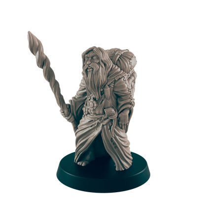 A miniature dwarf figure stands, holding a twisted staff; he wears a robe and carries a pack.  The figurine is displayed on a dark circular base against a black background.
