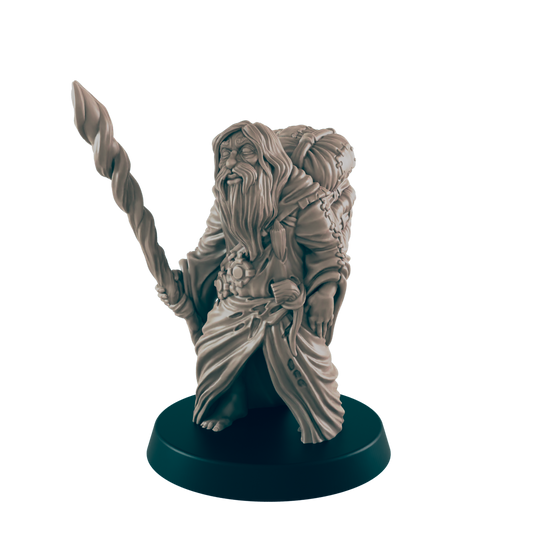A miniature dwarf figure stands, holding a twisted staff; he wears a robe and carries a pack.  The figurine is displayed on a dark circular base against a black background.