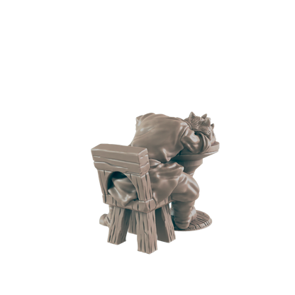 A miniature figurine of a person slouched over a simple wooden chair, appearing to be asleep or resting; the scene is isolated against a black background.