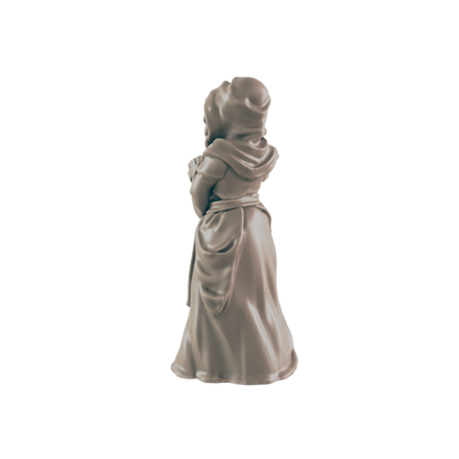 A miniature figurine of a woman, appearing to hold something, stands against a black background.  She wears a long robe and hooded cloak.