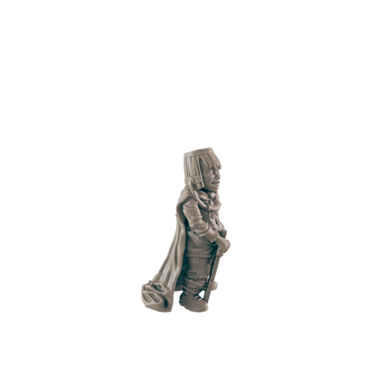 A miniature figurine of a grinning, cloaked figure stands, holding a staff; it’s positioned against a dark background.