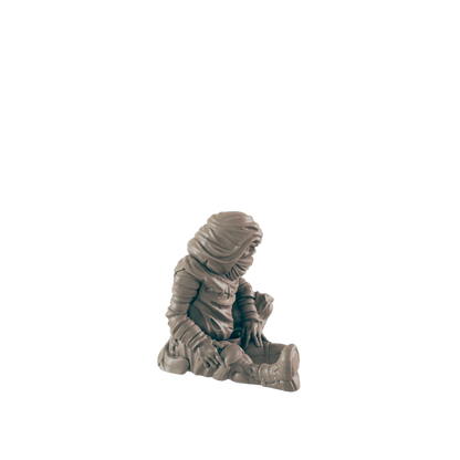 A small, hooded figure sits hunched over, appearing to be examining something in its lap, against a black background.