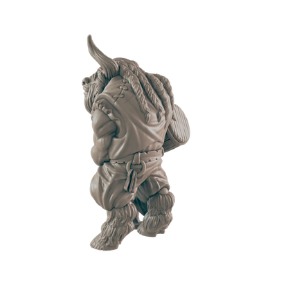 A miniature figurine of a Minotaur, carrying a shield, walks against a black background.
