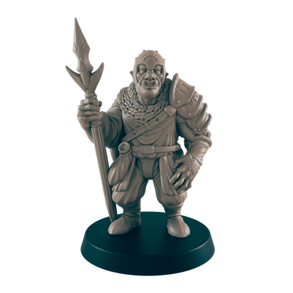 A miniature orc figure stands holding a spear.  He wears armor and a cloak.  The figure is displayed on a dark circular base.