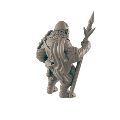 A miniature figurine of a stout, cloaked figure holds a spear-like staff.  The figure stands, viewed from behind, against a plain background.