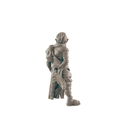 A miniature figurine of a humanoid figure, possibly an elf, stands facing away, wearing tattered clothing and sandals against a dark background.