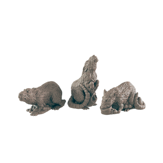 Three rat-like figurines are posed; one is crouched, one sits upright, and one lies down.  They are arranged in a row against a black background.