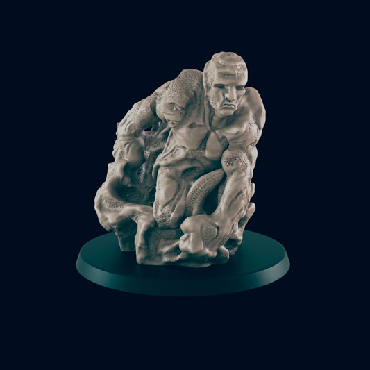 A sculpted humanoid figure, seemingly struggling against a parasitic growth, rests on a dark circular base.
