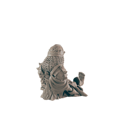 A miniature figurine, depicting a seated armored figure, rests on a plain background.