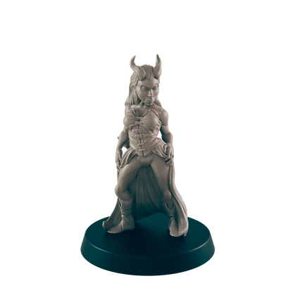 A miniature female figure, horned and cloaked, stands on a round base.  The figurine is sculpted in a pose suggesting confidence or defiance.  The setting is a dark background, highlighting the sculpture.