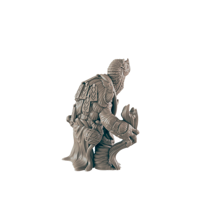 A miniature figurine of a tree-like creature, holding a staff, sits against a dark background.