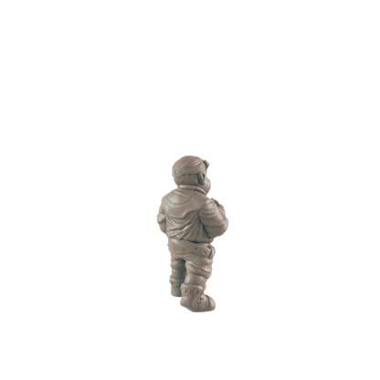 A small figurine, appearing to be a stout person in a jacket and boots, stands against a dark background.