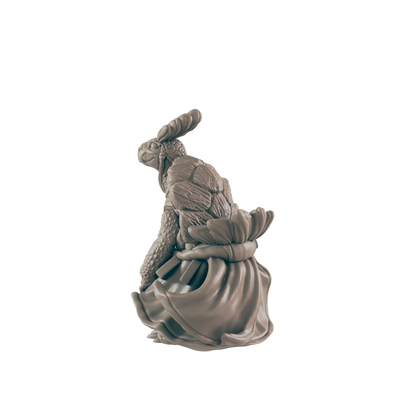 A turtle figurine, wearing a flowing dress and bunny ears, sits against a dark background.