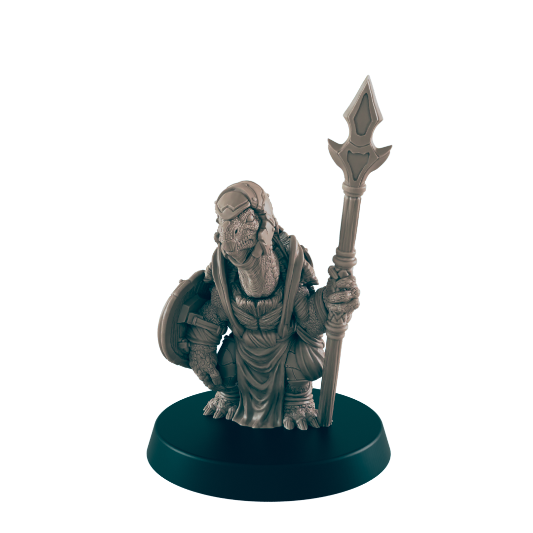 A turtle-like miniature figure stands holding a spear; it wears a robe and carries a shield.  The miniature is displayed on a circular base.
