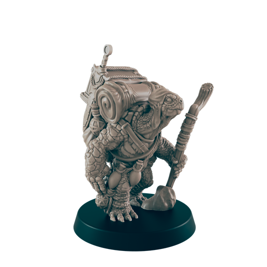A turtle-like miniature figure carries a backpack and staff, standing on a dark circular base.