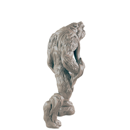 A hairy ape-like creature figurine, crouching, is presented against a dark background.